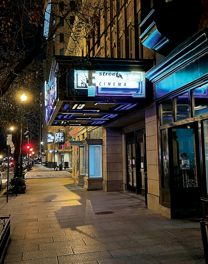 Entrance to E Street Cinema at night. The theater sign is lit up.